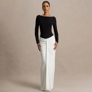 Ensemble haut noir à manches longues et jupe longue drapée blanche pour un look élégant