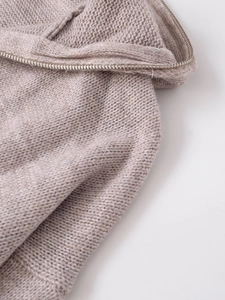 Detailed macro view of the coarse knit texture and metal zipper on this wool hoodie