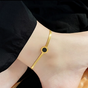 Elegant gold titanium anklet featuring a Roman numeral circular pendant on a flat chain