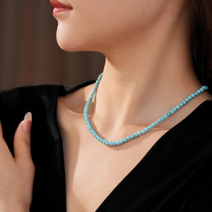 Detailed close-up of small round turquoise beads on a minimalist collar necklace for women
