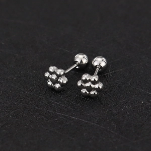 Detailed macro view of silver flower stud earrings with secure screw-back ball closures