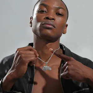Gros plan du pendentif hip hop argenté avec strass brillants porté par un mannequin homme