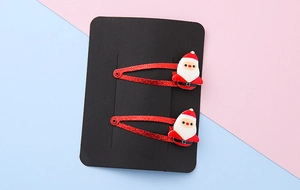Detail of Christmas Santa Claus hair clips with red glitter finish on a display card