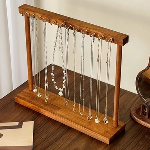 Minimalist wooden necklace display stand with gold metal hooks on a solid wood base