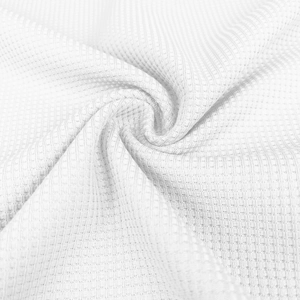 Close-up of white waffle texture fabric showing the intricate knit structure and softness