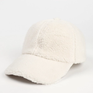 Close-up of soft white lamb wool texture and stitching details on this winter baseball cap