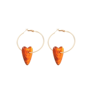 Golden hoop earrings featuring orange amber-textured acrylic heart pendants on white backdrop