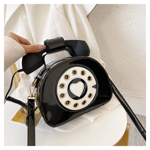 Detailed view of creative black retro telephone crossbody bag with heart dial design