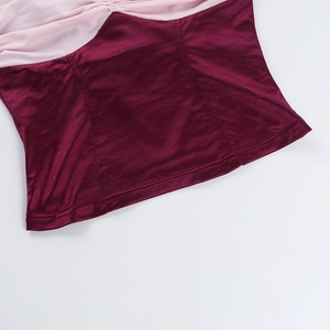 Dettaglio ravvicinato del tessuto satinato rosa e bordeaux con eleganti pieghe cucite