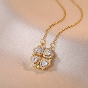 Détail du collier trèfle doré avec zircons en forme de cœur sur un tissu en satin luxueux