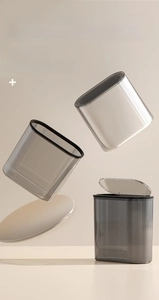 Close-up of translucent grey trash can featuring vertical stripe texture and pop-up lid
