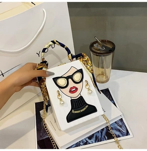 Detailed view of white box bag featuring a modern female portrait with 3D pearl earrings