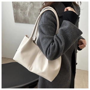 Detail of soft cream PU leather tote bag with vertical stitching on grey wool coat
