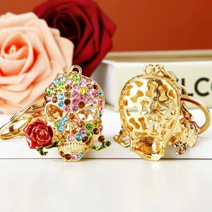 Detail of colorful rhinestone skull keychain with red rose and golden hollow structure
