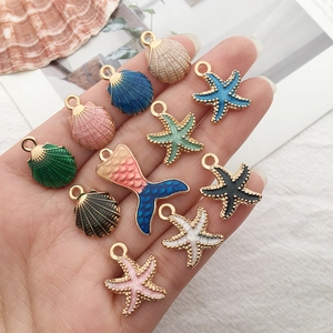 Close-up of ocean-themed enamel alloy pendants featuring starfish and seashell designs