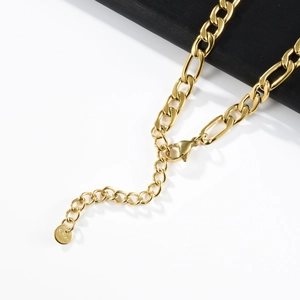Detail of golden stainless steel Figaro chain featuring lobster clasp and extension