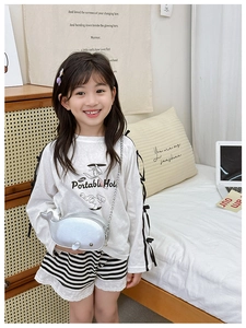 Detail of silver whale-shaped children shoulder bag with metallic chain on model
