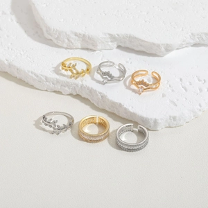 Dettaglio di un set di 6 anelli con zirconi a forma di ramo e corona in oro e argento