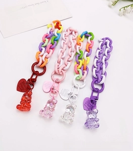 Detail of colorful acrylic wrist straps featuring transparent gummy bears and heart tags