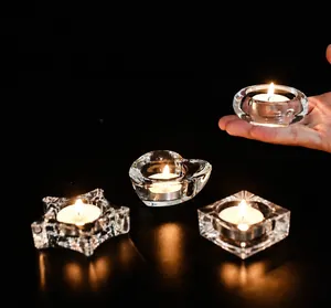 Close-up of heart and star shaped glass candle holders with lit white tea lights