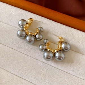Macro detail of French style C-shape hoop earrings with gradient grey pearls and gold base