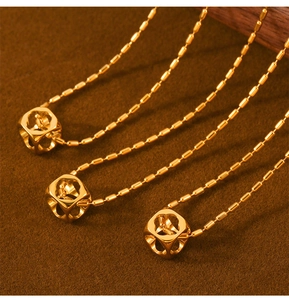 Detailed close-up of three gold hollow cube pendants on beaded stainless steel chains