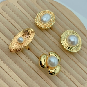 Detailed view of vintage gold plated rings with white pearls and embossed textures