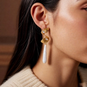 Detailed view of vintage gold twisted earrings with teardrop pearl on model