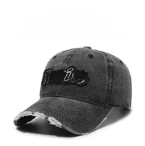 Detail of distressed baseball cap featuring Purist embroidery and frayed brim details