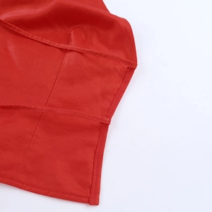 Détail macro du tissu en satin rouge brillant et de l'ourlet à double couture durable