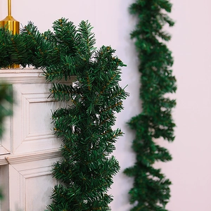 Detail showing artificial green Christmas garland draped on a vintage white fireplace mantel