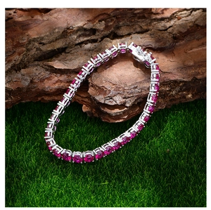 Detail eines roten Tennisarmbandes mit silberfarbener Krappenfassung auf Moos