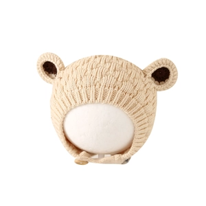 Beige knit baby hat with bear ears and chin strap for warmth in winter season