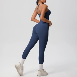Back view of navy blue backless yoga jumpsuit with thin crisscross straps on model