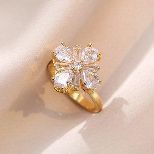 Close-up of a rotating golden flower ring with sparkling cubic zirconia on beige fabric