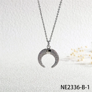 Detailed close-up of a silver horn pendant with micro-paved white cubic zirconia stones