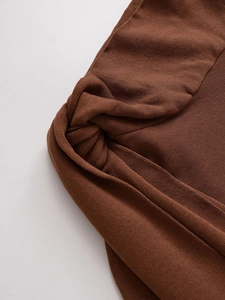 Detailed view of dark brown knit sweater showing high-density fabric and twist design