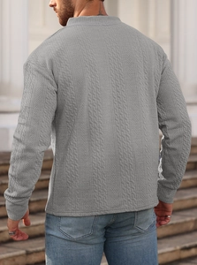 Close-up of light gray waffle knit texture and fabric detail on men's long sleeve top