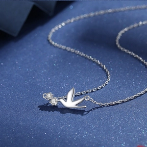 Elegant S925 sterling silver bird necklace with sparkling zircons on blue fabric