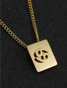 Macro detail of 18K gold plated Cancer zodiac square pendant on a delicate link chain