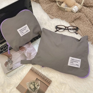 Detail of grey waterproof travel storage bags with purple zippers on soft white textile