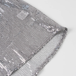 Vue rapprochée de paillettes gris argenté sur résille avec texture rayée et éclat