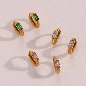 Détail de trois boucles d'oreilles dorées avec oxydes de zirconium vert, blanc et rose