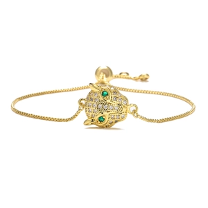 Macro detail of gold plated leopard head bracelet with green zircon eyes and crystals