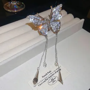 Pince à cheveux papillon étincelante avec pompons argentés et strass en cristal