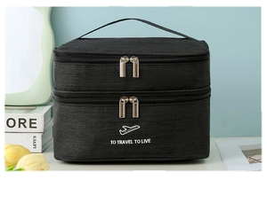 Close-up of a black double-layer travel toiletry bag with handle and travel slogan