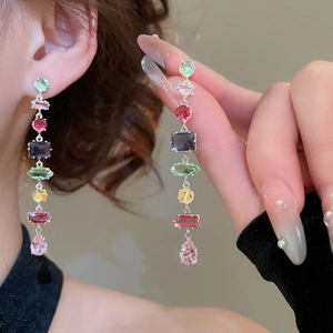 Detail of long drop earrings featuring colorful geometric zircons on silver base