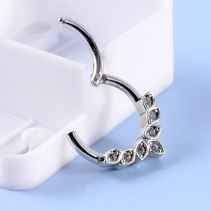 Macro view of silver hinged clicker with V-shaped clear stones for nose or ear
