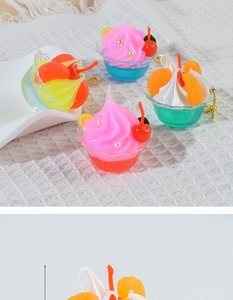 Close-up of mini dessert keychain charms with cream texture and fruit toppings