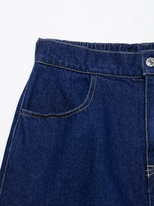 Detailed macro view of dark blue denim shorts with contrast stitching and elastic waistband